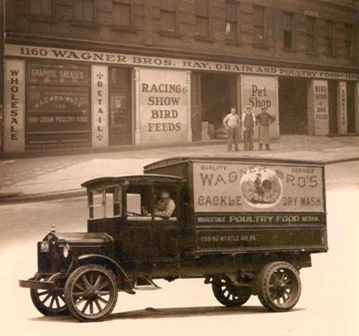 An early Wagner Bros. storefront lettered Hay, Grain and Poultry Food, with a delivery truck at the curb